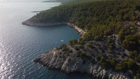 Orbit-shot-around-secluded-wild-beach-in-Brac-island,-Croatia,-revealing-turquoise-waves-hitting-the-rocky-shore