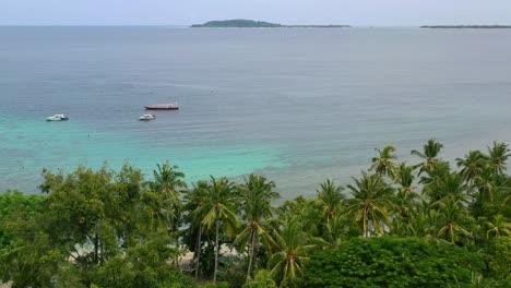 Boote-Verankert-Im-Tropischen-Ozean-Von-Mentigi-Bay-Lombok-Mit-Gili-Inseln-Am-Horizont,-Antenne