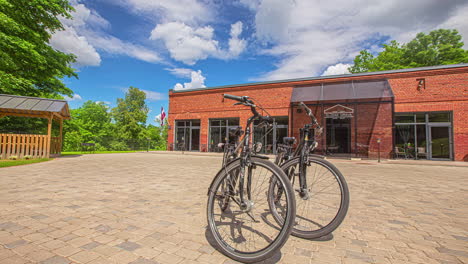 Two-vintage-bicycles-outside-a-brick-storefront-on-a-sunny-summer-day---dynamic-parallax-motion-time-lapse