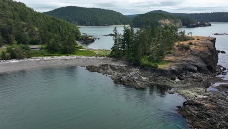 Rising-drone-shot-over-the-Rosario-Head-land-mass-to-reveal-Deception-Pass-and-Whidbey-Island-in-the-background
