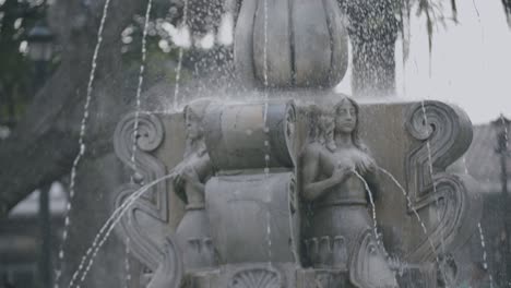 Zeitlupenaufnahmen-Eines-Brunnens-Mit-Frauenskulpturen,-Denen-Wasser-Aus-Der-Brust-Spritzt