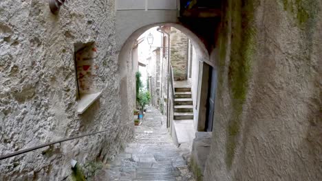 Walking-down-the-steps-in-the-ancient-village-of-Corenno-Plinio-on-the-shore-of-Lake-Como,-Italy