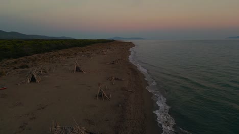 Flying-over-Maremma-National-Park-beach-with-panoramic-evening-sunset-sky-in-Tuscany,-Italy