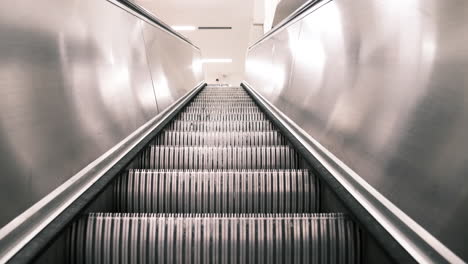 Static-footage-of-escalators-stairs-and-man-at-the-top-of-the-escalator-getting-off