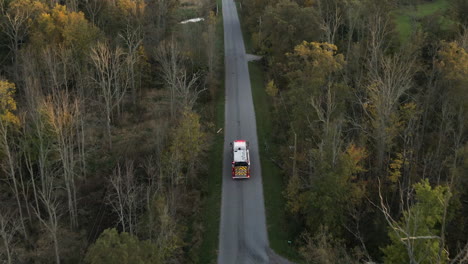 Aerial-Tracking-View-of-Emergency-Fire-Truck-Vehicle-Driving-Moving-Fast-along-Countryside-Rural-Road-with-Flashing-Lights,-Rescue-First-Responder-Mission-for-Fire-Fighting-Accident-Alert