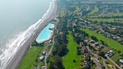 Coastal-Luxury-Resort-with-golf-courses,-Giant-swimming-pool-by-the-Ocean,-Aerial-view