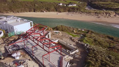 Aerial-shot-steel-frame-construction-overlooking-seaside-in-Cornwall