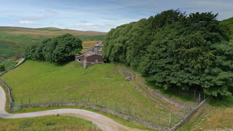 Aerial-drone-video-footage-of-a-reservoir-dam-wall-and-moving-towards-a-Farmhouse,-showing-overflow-structures