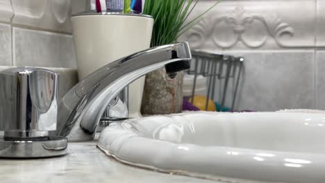 The-shiny-faucet-dripping-water-in-the-bathroom