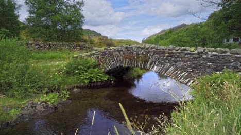 Video-footage-of-Watendlath's-attractive-packhorse-bridge-sitting-over-the-Watendlath-beck,-this-is-the-source-for-Lodore-Falls-–-a-tourist-attraction-from-Victorian-times