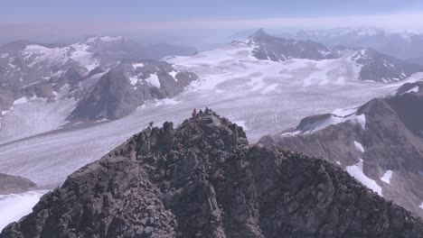 Montañero-Acercándose-A-La-Cumbre-De-Un-Pico-Masivo-Rodeado-De-Montañas-Y-Glaciares