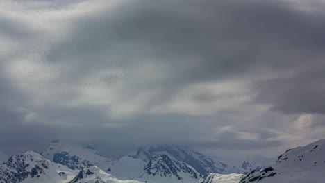 Zeitrafferaufnahme-Der-Wolkenlandschaft-über-Schneebedeckten-Berggipfeln---Dramatische-Winterlandschaft-In-Großer-Höhe