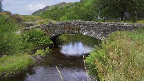 Watendlath's-attractive-stone,-packhorse-bridge-sitting-over-the-Watendlath-beck,-this-is-the-source-for-Lodore-Falls-–-a-tourist-attraction-from-Victorian-times