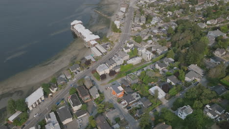 Aerial-pan-up-over-the-Alki-Point-neighborhoods-revealing-the-waters-outside-of-Seattle,-WA
