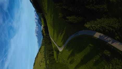 Vertical-Bavarian-Austrian-Sudelfeld-Wendelstein-alps-mountain-peaks-with-romantic-and-idyllic-green-grass-meadows-and-panorama-view-road