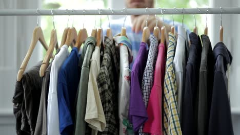Close-up-of-man-tidying-up-clothes-of-coat-rack