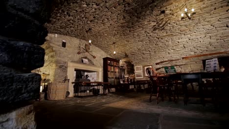 Interior-of-an-ancient-medieval-castle-room-in-Scotland,-pan-shot
