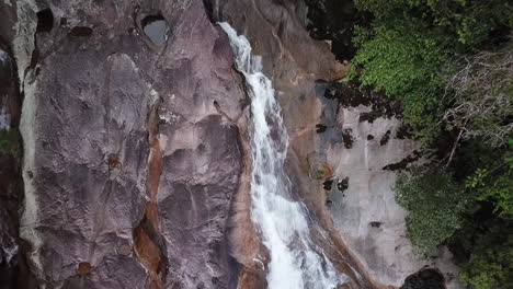 Aerial-shot-of-the-Guaratuba-waterfall,-zooming-out-from-a-close-up-to-a-wide-shot
