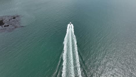 Symmetrical-aerial-view-of-a-motorboat-traveling-through-the-Pacific-Ocean