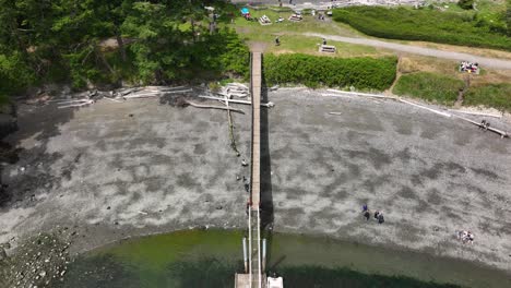 Overhead-view-of-a-long-dock-extending-out-to-a-few-dinghies-at-low-tide
