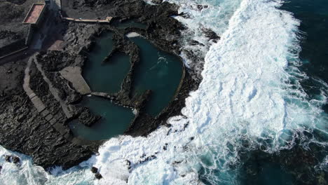 Fantastic-aerial-shot-from-above-of-the-coast-of-Agaete-and-specifically-of-its-natural-pools-where-the-ocean-breaks-the-coast-with-force
