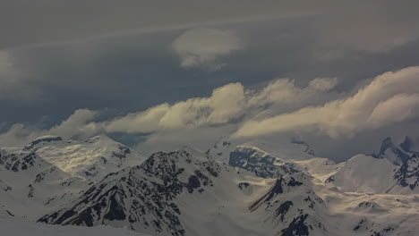 Clouds-rolling-over-snowy-winter-mountain-peaks-in-the-Alps---cloudscape-time-lapse