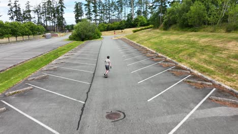 Aerial-of-an-adult-male-riding-a-One-Wheel-through-an-empty-parking-lot