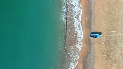 Overhead-aerial-image-of-a-beach-with-a-small-fishing-boat-static-shot