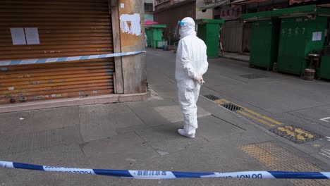 A-health-worker-dressed-in-a-PPE-suit-is-seen-standing-guarded-inside-a-neighborhood-area-under-lockdown-to-contain-the-spread-of-the-Coronavirus-variant-outbreak-in-Hong-Kong