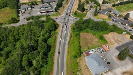 Top-down-aerial-view-of-cars-driving-on-the-main-highway-through-Whidbey-Island