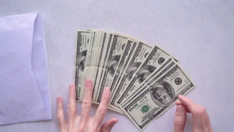 Hands-Taking-Out-Bundle-Of-One-Hundred-Dollar-Bills-From-An-Envelope