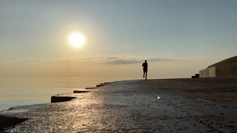 Silhouette-of-a-runner-going-away-from-the-camera-along-the-Chicago-lakefront-at-sunrise