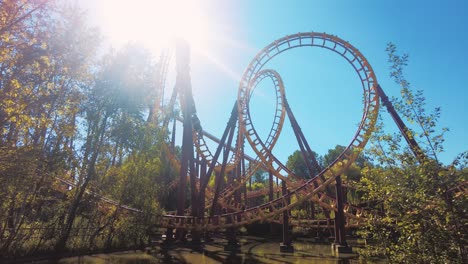 Yellow-red-roller-coaster-looping-in-parc-Asterix-on-a-sun-flare-fun-summer-day
