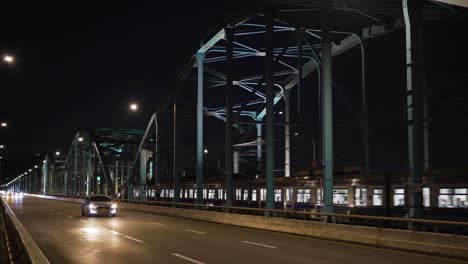 Metro-train-traveling-on-Dongjak-Bridge-from-Dongjak-subway-station-at-night-and-cars-traffic-in-real-time,-Seoul-night-life