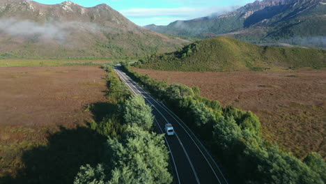 A-large-white-van-driving-down-the-road-on-the-West-Coast-of-Tasmania-in-Australia