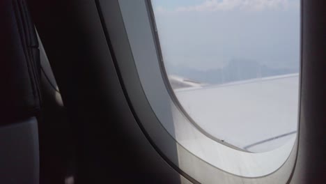 Blick-Auf-Die-Flugzeugtragfläche-Durch-Das-Flugzeugfenster