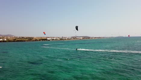 Close-up-Tracking-Shot-Of-Individuals-Kitesurfing-Off-The-Coast-Of-Greece