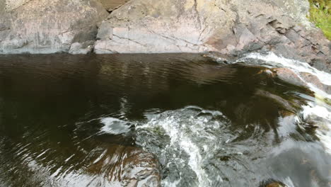 Aguas-Abajo-Con-Agua-Espumosa-Fluye-Rápidamente-Sobre-Las-Rocas