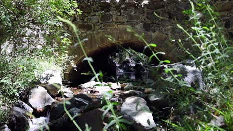 Static-Shot-Of-Water-Slowly-Flowing-Under-A-Bridge-At-The-Troodos-Mountains,-Cyprus