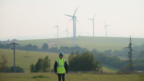 A-technician-with-plans-walks-through-a-wind-farm-in-Krystofovy-Hamry