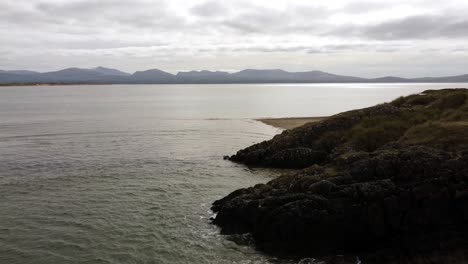Luftumkreisende-Ansicht-Ynys-Llanddwyn-Island-Anglesey-Küstenwanderweg-Mit-Snowdonia-bergen-über-Der-Irischen-See