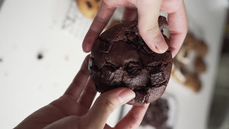 Vertical-Shot-Of-Female-Hands-Splitting-Double-Chocolate-Fudge-Cookie