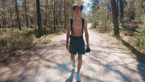 Total-wide-front-shot-young-shirtless-teenage-walking-in-forest-in-fontainebleau