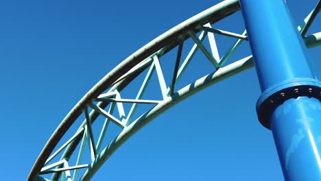 Close-up-blue-roller-coaster-track-in-amusement-park-on-a-sunny-day-clear-skies