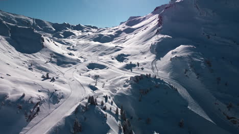 Aerial-view-of-groomed-ski-run,-chair-lift,-people-skiing-at-Avoriaz-Ski-Resort,-French-Alps