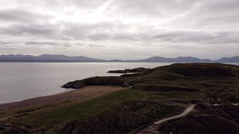 Luftüberführung-Blick-Auf-Ynys-Llanddwyn-Island-Anglesey-Küstenwanderweg-Mit-Snowdonia-bergen-über-Der-Irischen-See