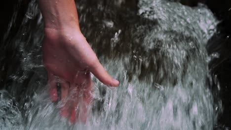 Hand-gliding-trough-a-small-waterfall-with-clear-and-fresh-and-cold-water