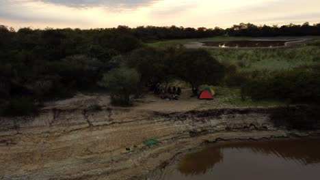 Aerial-Shot-At-Dawn-Time,-Group-Of-Fishermen-Camping-On-Tebicuary-River-Side,-Paraguay