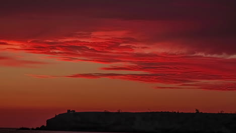 Bright-orange-glowing-sunset-along-the-coastline-in-Morocco---time-lapse