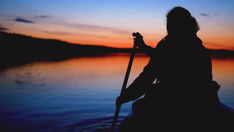 Static-view-of-a-woman-paddling-a-canoe-on-lake